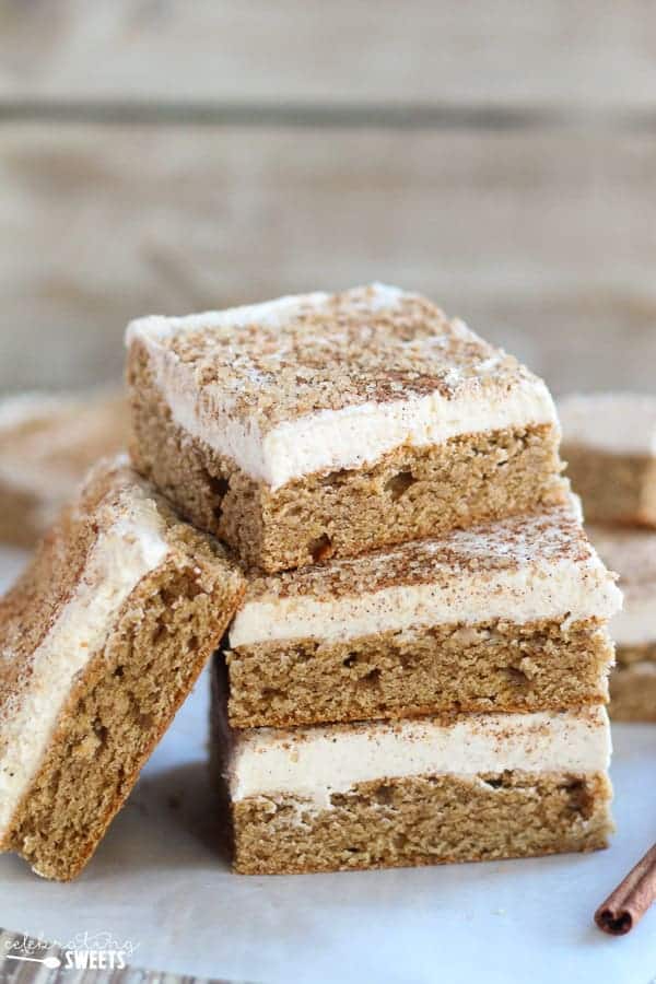Stack of cookie bars topped with frosting and cinnamon sugar.