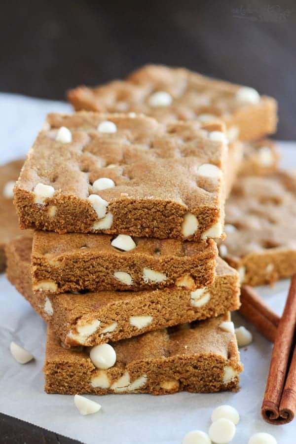 Stack of gingerbread cookie bars filled with white chocolate chips.
