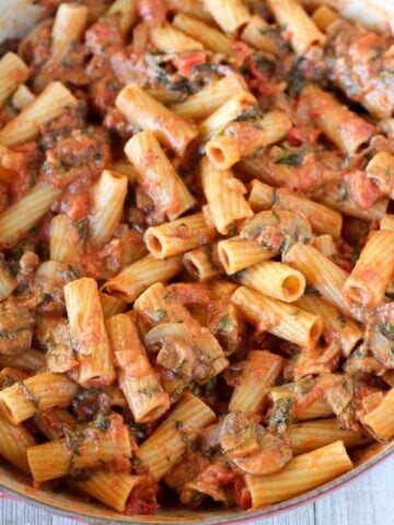 Pasta with mushrooms, red sauce and spinach.