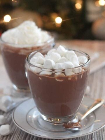 Hot chocolate in a glass topped with marshmallows.
