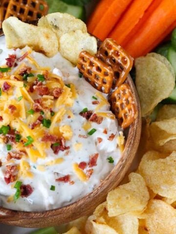 Chips and dip topped with bacon, cheese, and chives.