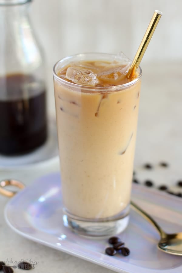 Iced coffee in a glass with a gold straw