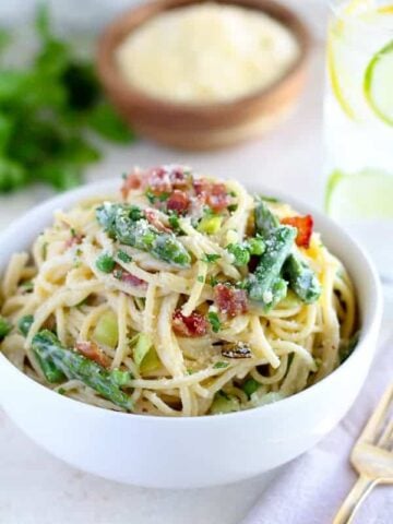 Bowl of pasta with asparagus and bacon.