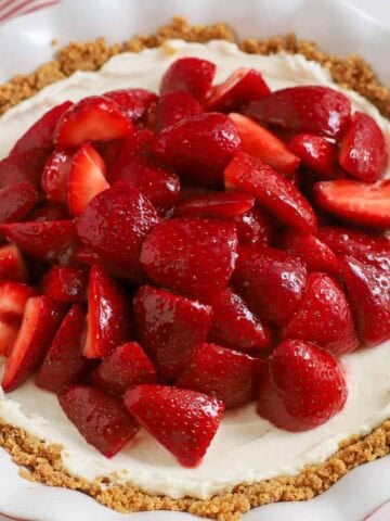 Strawberry cream cheese pie in a graham cracker crust in a white pie plate,