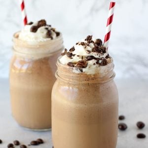 Coffee frappe in a mason jar topped with whipped cream.