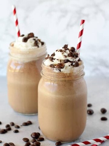 Coffee frappe in a mason jar topped with whipped cream.