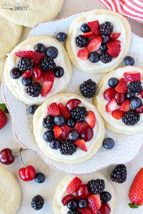 Sugar cookies topped with frosting and berries.