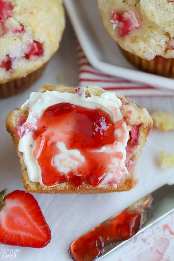 Strawberry muffin split in half and topped with butter and strawberry jam.