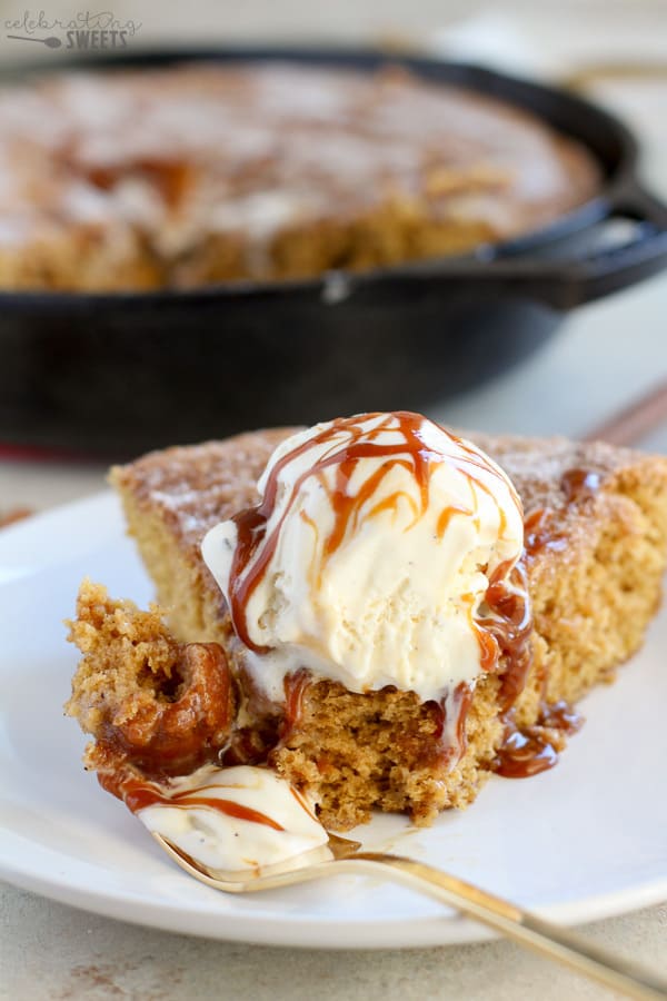 Slice of skillet cookie topped with ice cream and caramel sauce