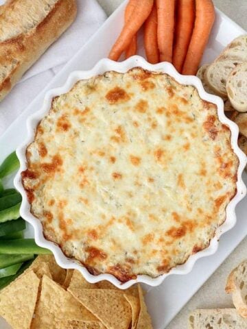 Artichoke dip in a white casserole dish