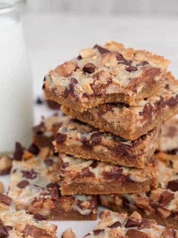 Stack of Peanut Butter Cup Magic Cookie Bars with Milk in the Background
