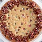 Giant chocolate chip cookie decorated with chocolate frosting and sprinkles.