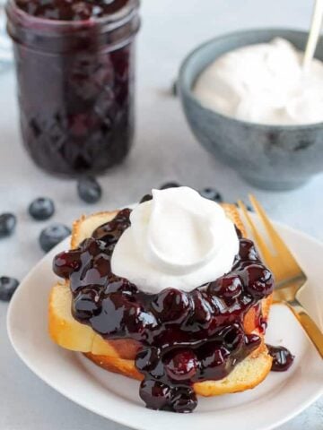 Blueberry Sauce on a Stack of Pound Cake with Whipped Cream.