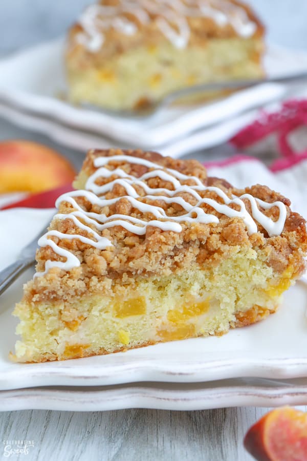 A slice of Peach Crumb Cake on a white plate.