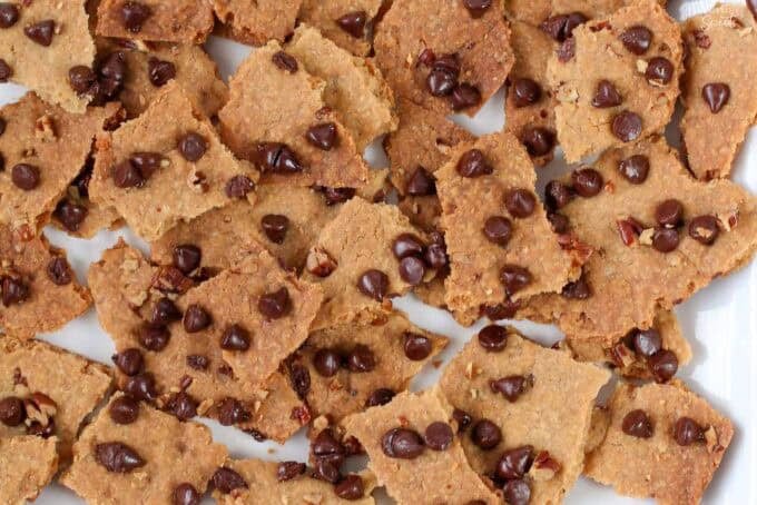 Pieces of chocolate chip cookie brittle on a white plate.