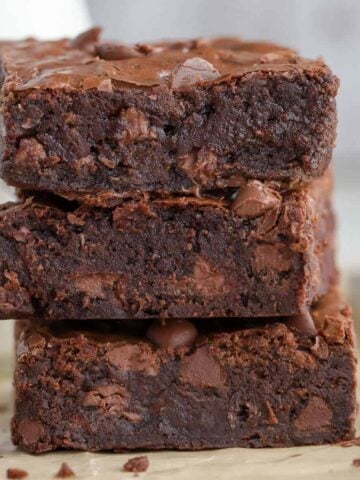 Stack of three brownies on parchment paper