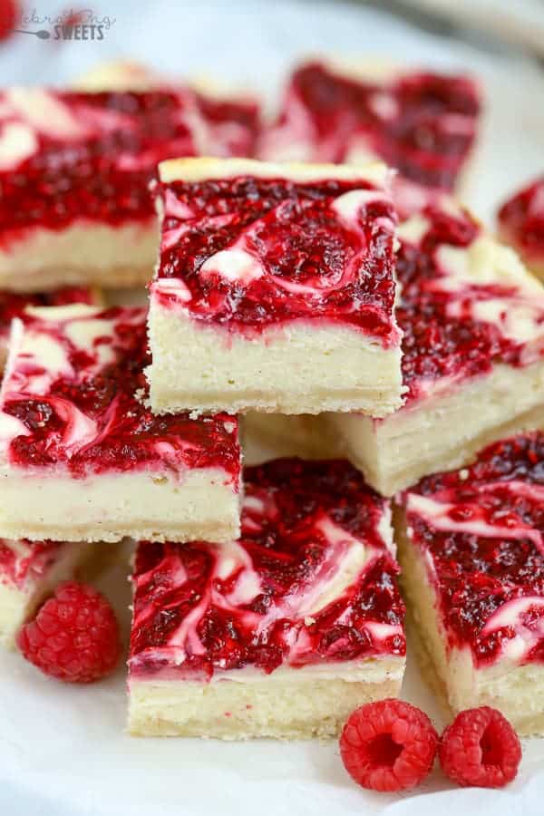 Pile of cheesecake bars swirled with raspberry puree.