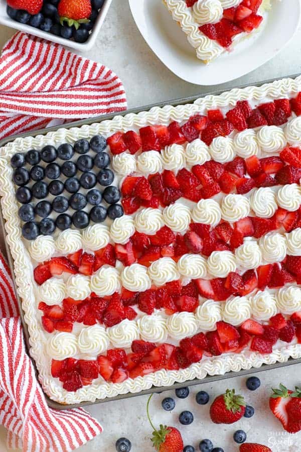American flag cake decorated with strawberries, blueberries and white frosting.
