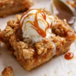 Apple crumb bar topped with vanilla ice cream and caramel sauce.