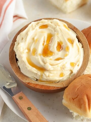 Maple butter in a brown bowl drizzled with maple syrup.