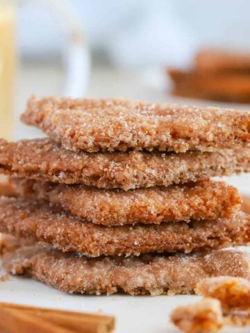 Stack of cinnamon cookies on parchment paper.