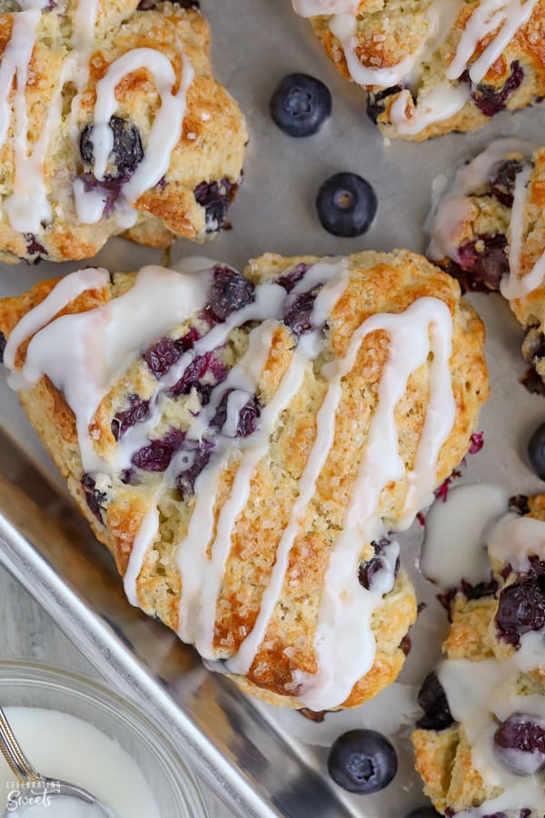 Triangular blueberry scone on a baking sheet.