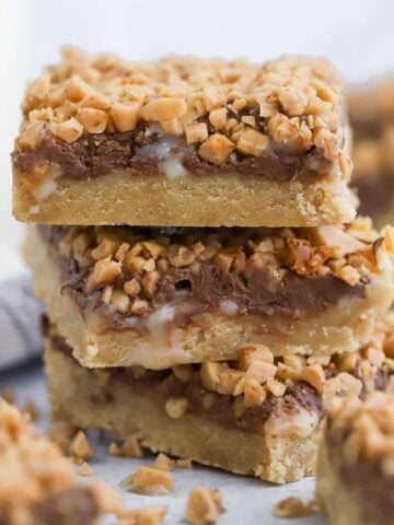 Stack of three toffee bars topped with chocolate and toffee bits,