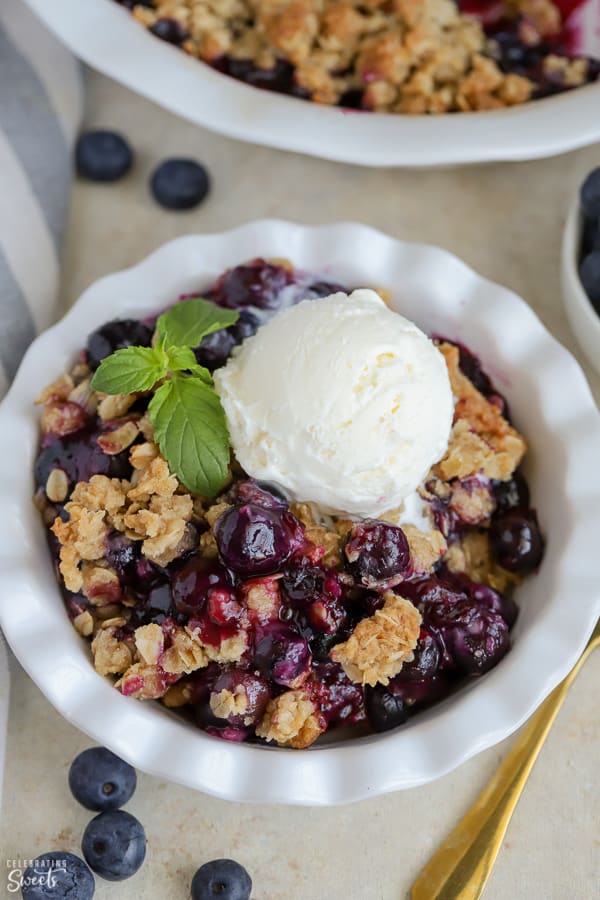 Blueberry Crisp topped with ice cream in a white bowl.