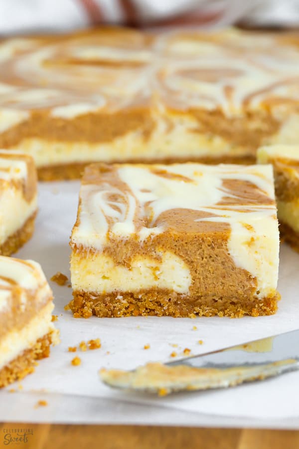 Pumpkin cheesecake bars on parchment paper.