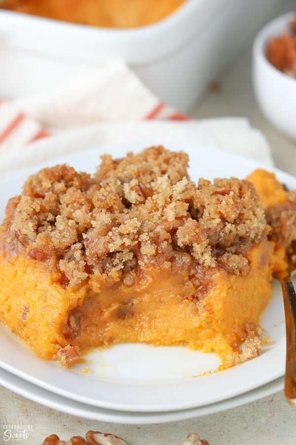 Sweet potato souffle on a white plate with a gold fork