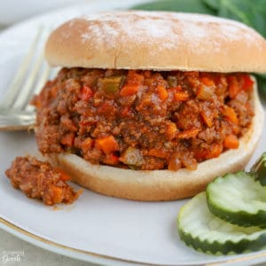 Sloppy joe sandwich on a plate with pickles