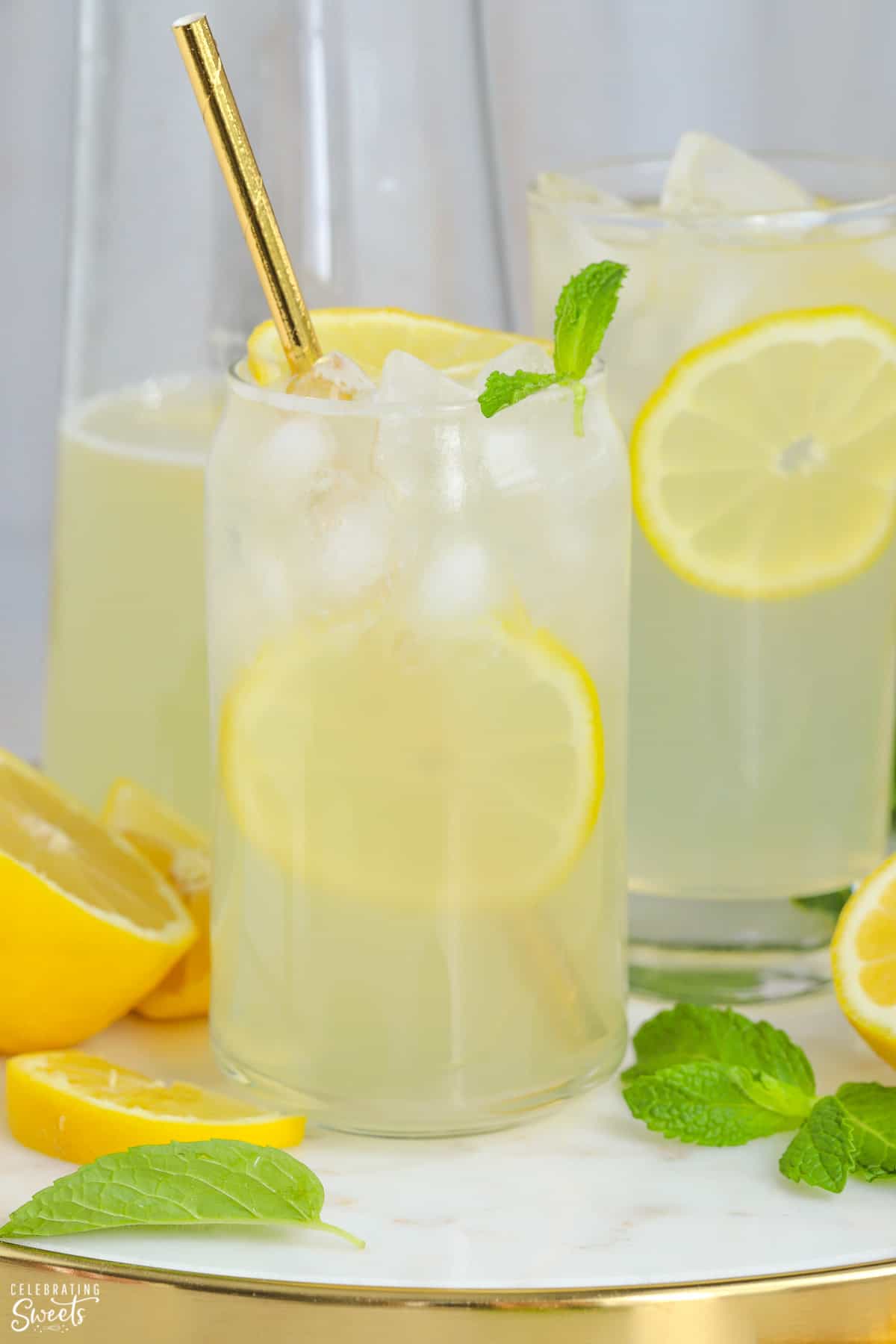 Glasses of lemonade garnished with lemon slices and mint.