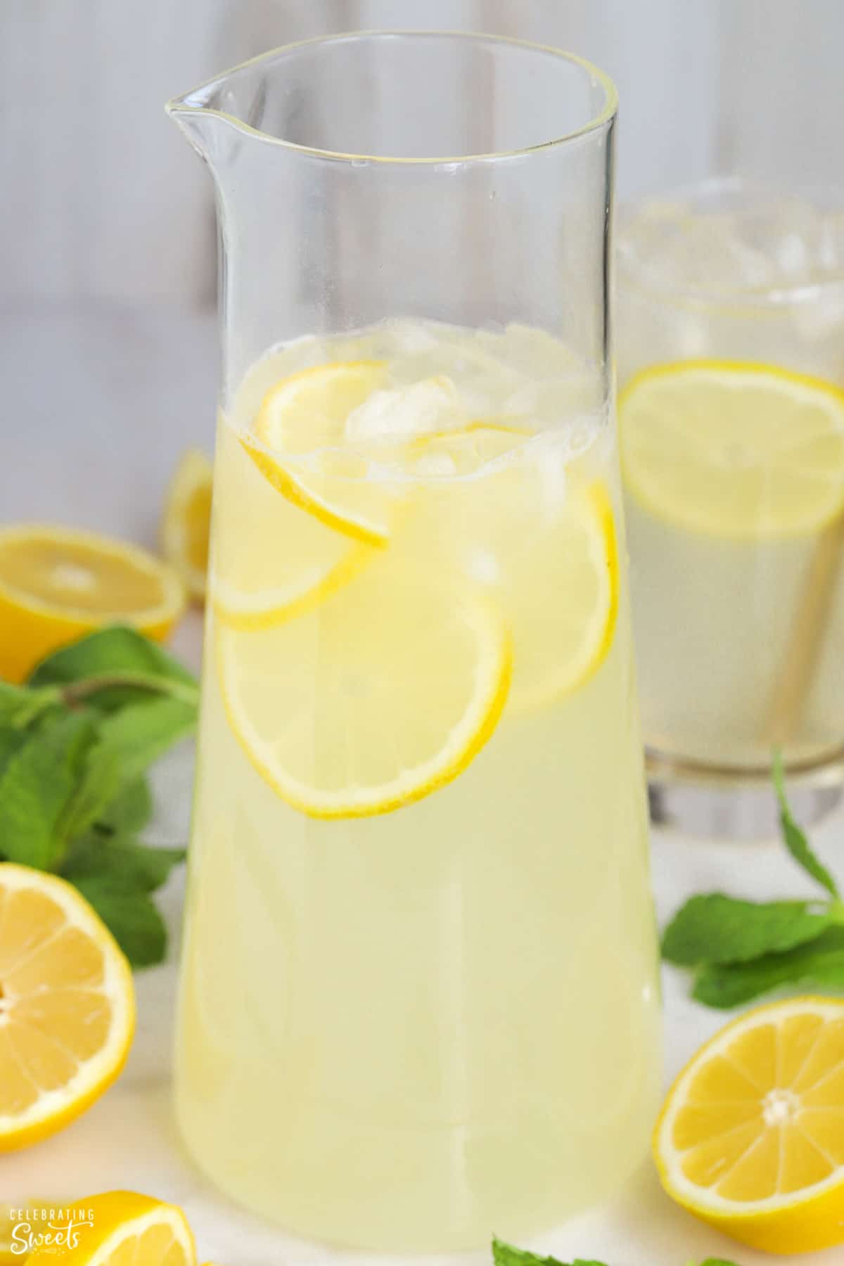 Pitcher of lemonade garnished with fresh lemon.