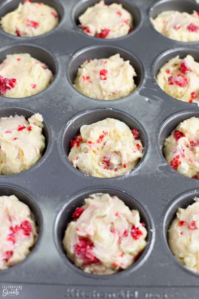 Raspberry muffin batter in a muffin tin