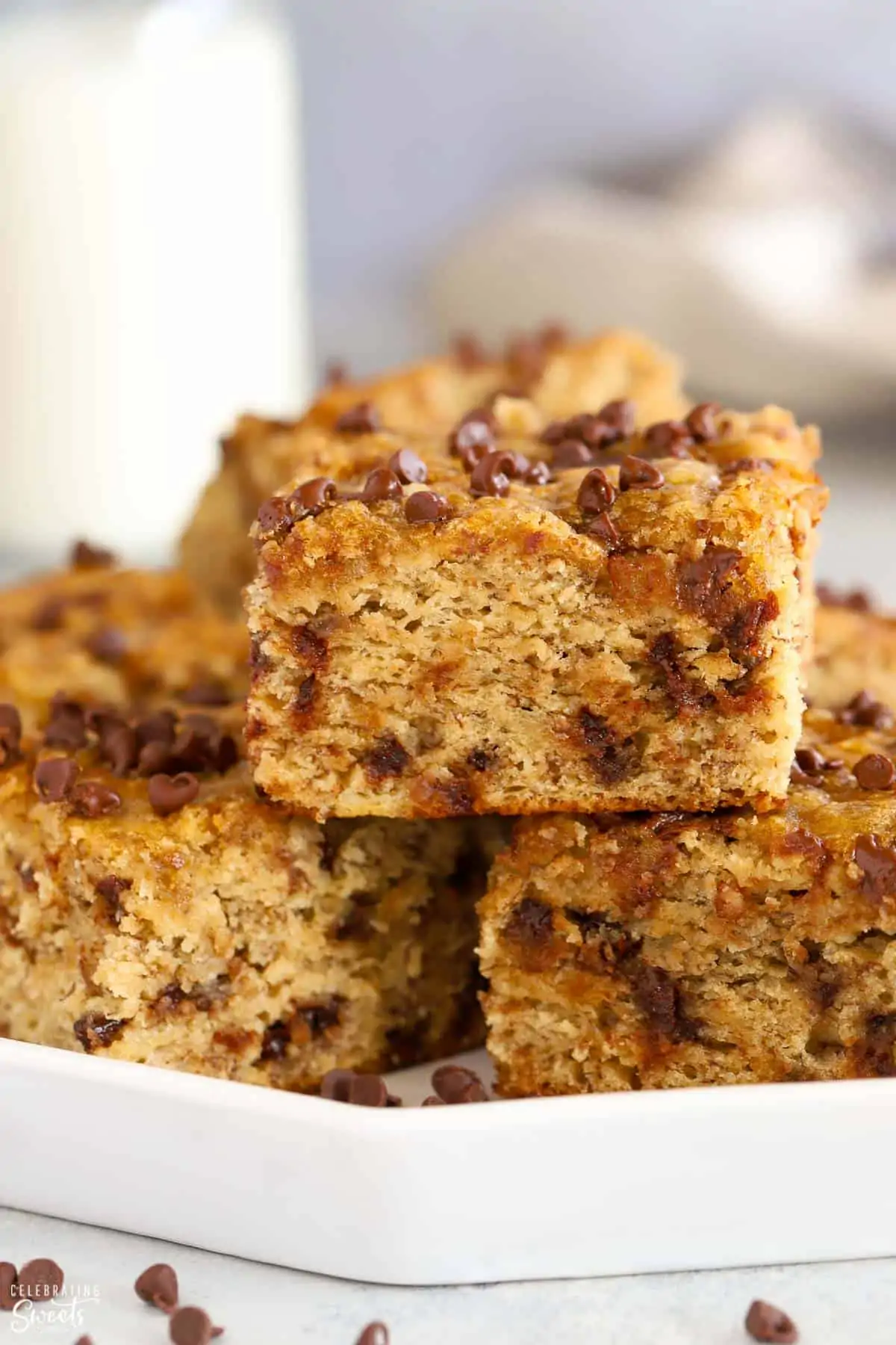 Square slices of chocolate chip banana bread on a white plate.