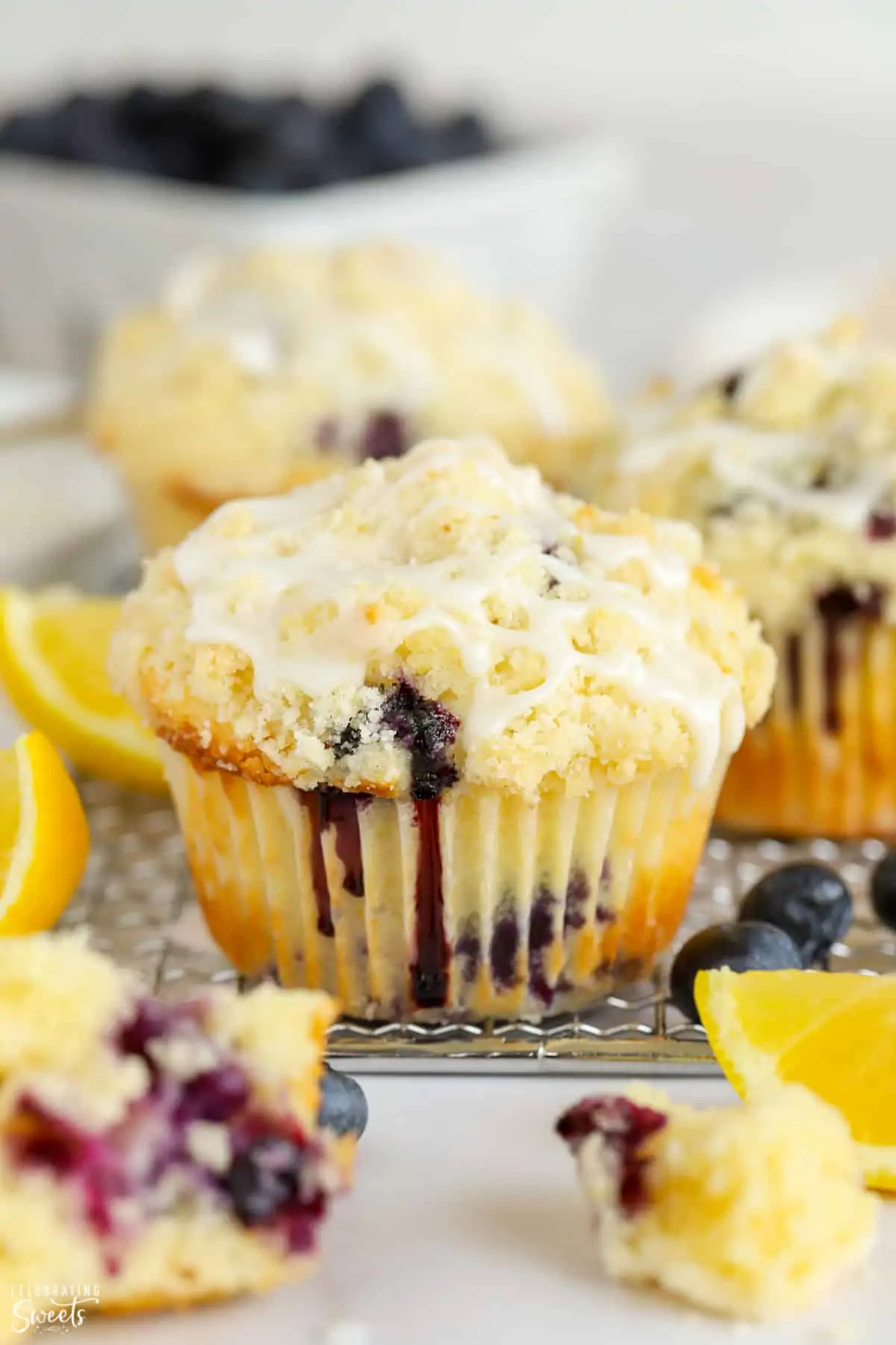 Closeup of a lemon blueberry muffin with crumb topping and white icing