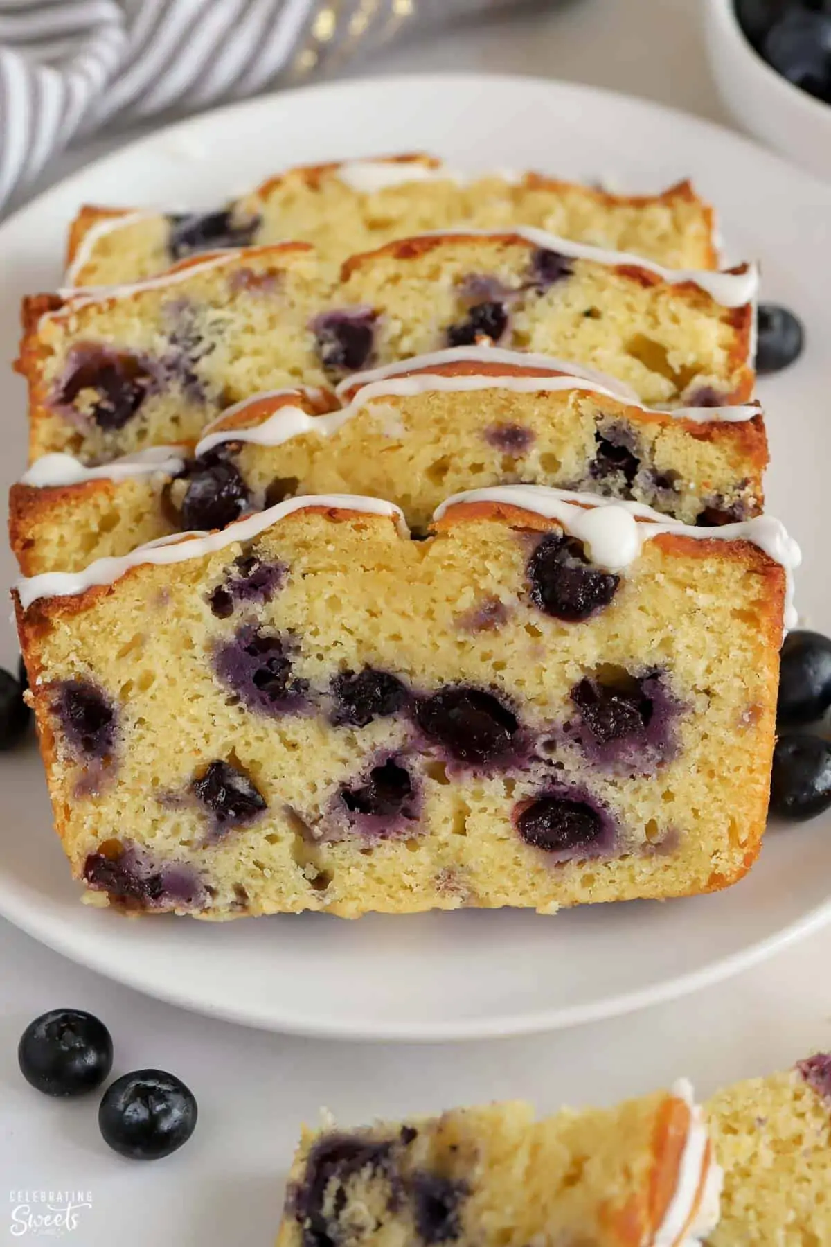 Four slices of blueberry bread on a white plate.