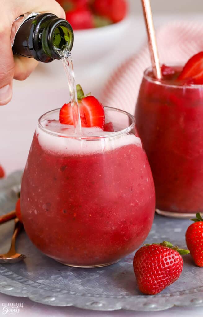 Frosé wine slushies in a glass on a silver tray being topped with champagne.