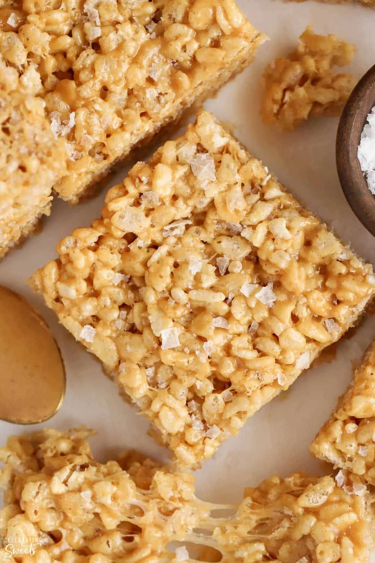 Closeup of peanut butter rice krispies treat topped with flaky sea salt.