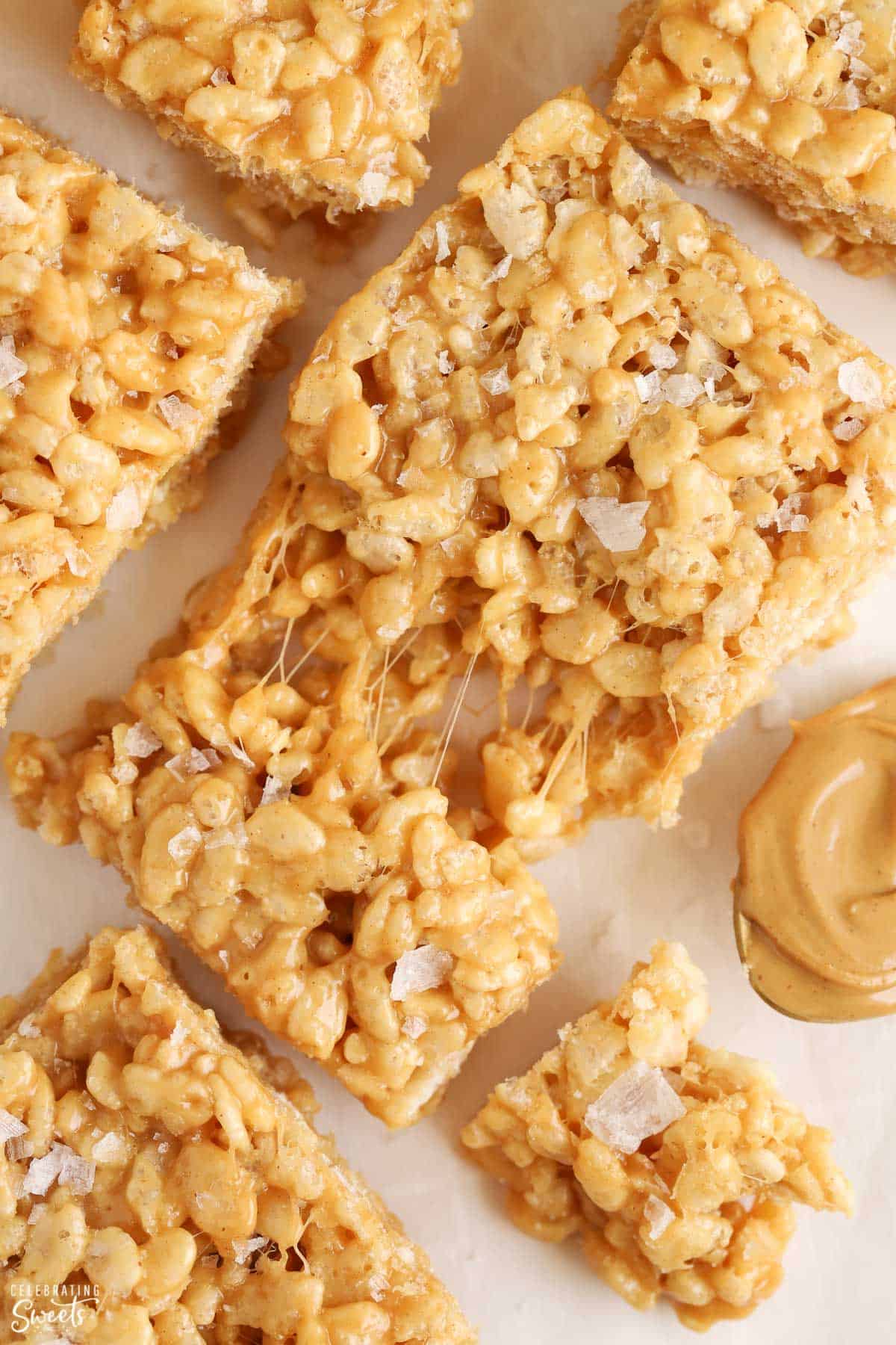 Closeup of a gooey peanut butter rice krispies treat topped with flaky sea salt.