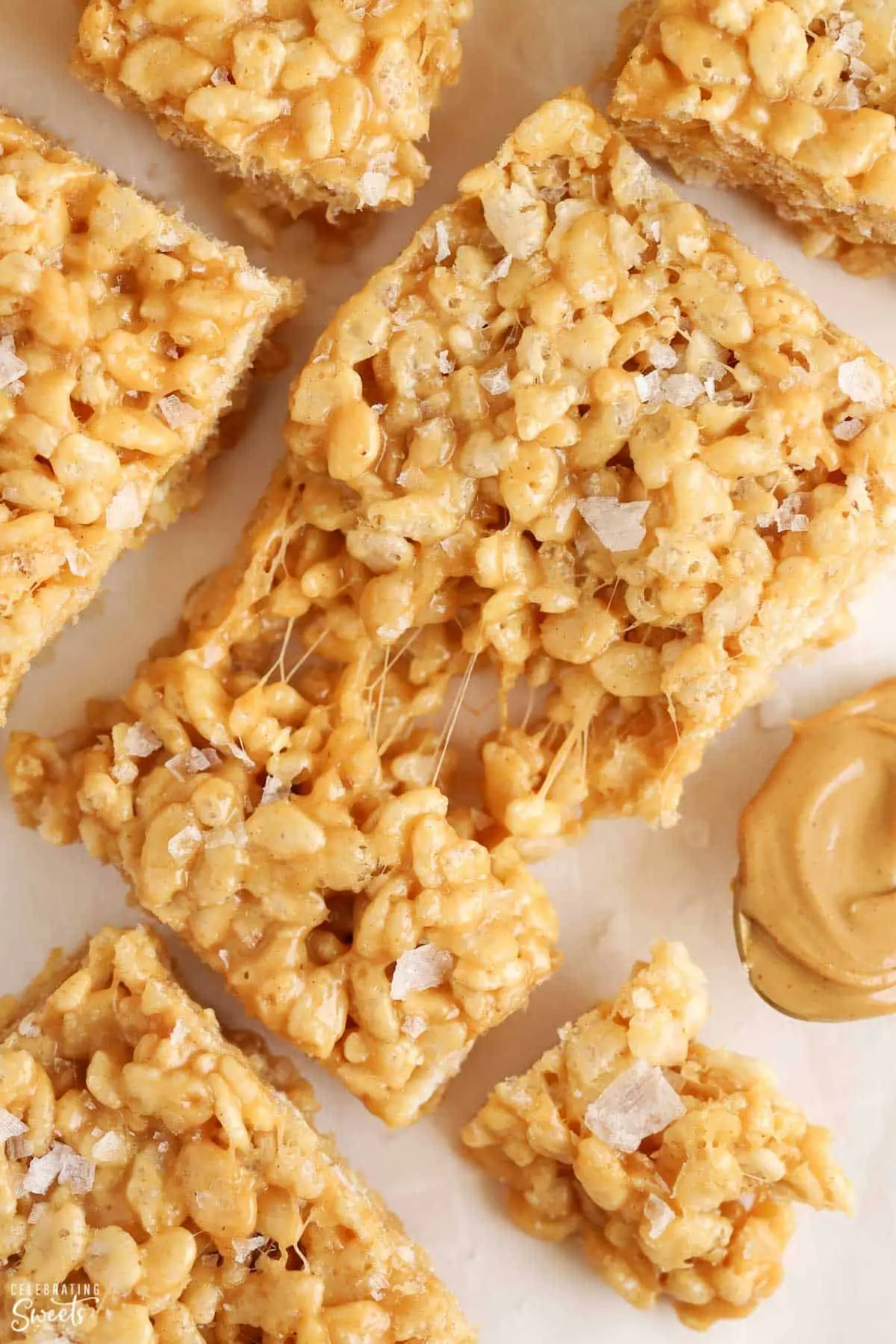 Closeup of a gooey peanut butter rice krispies treat topped with flaky sea salt.