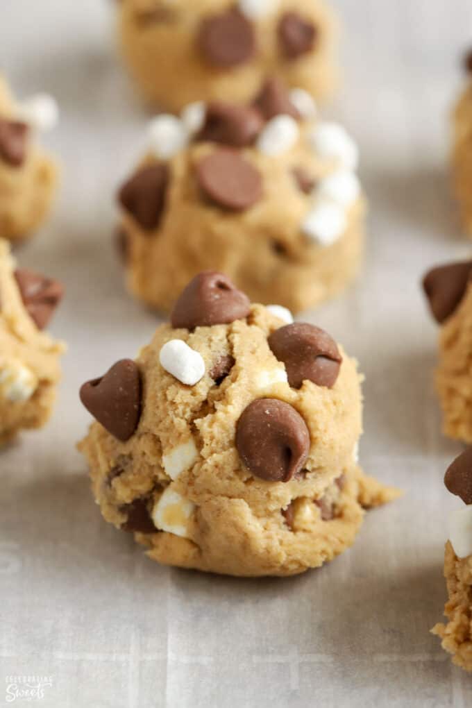 S'mores cookie dough balls on a parchment lined baking sheet.