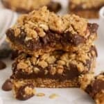 Two Oatmeal Fudge Bars stacked on a piece of parchment paper.