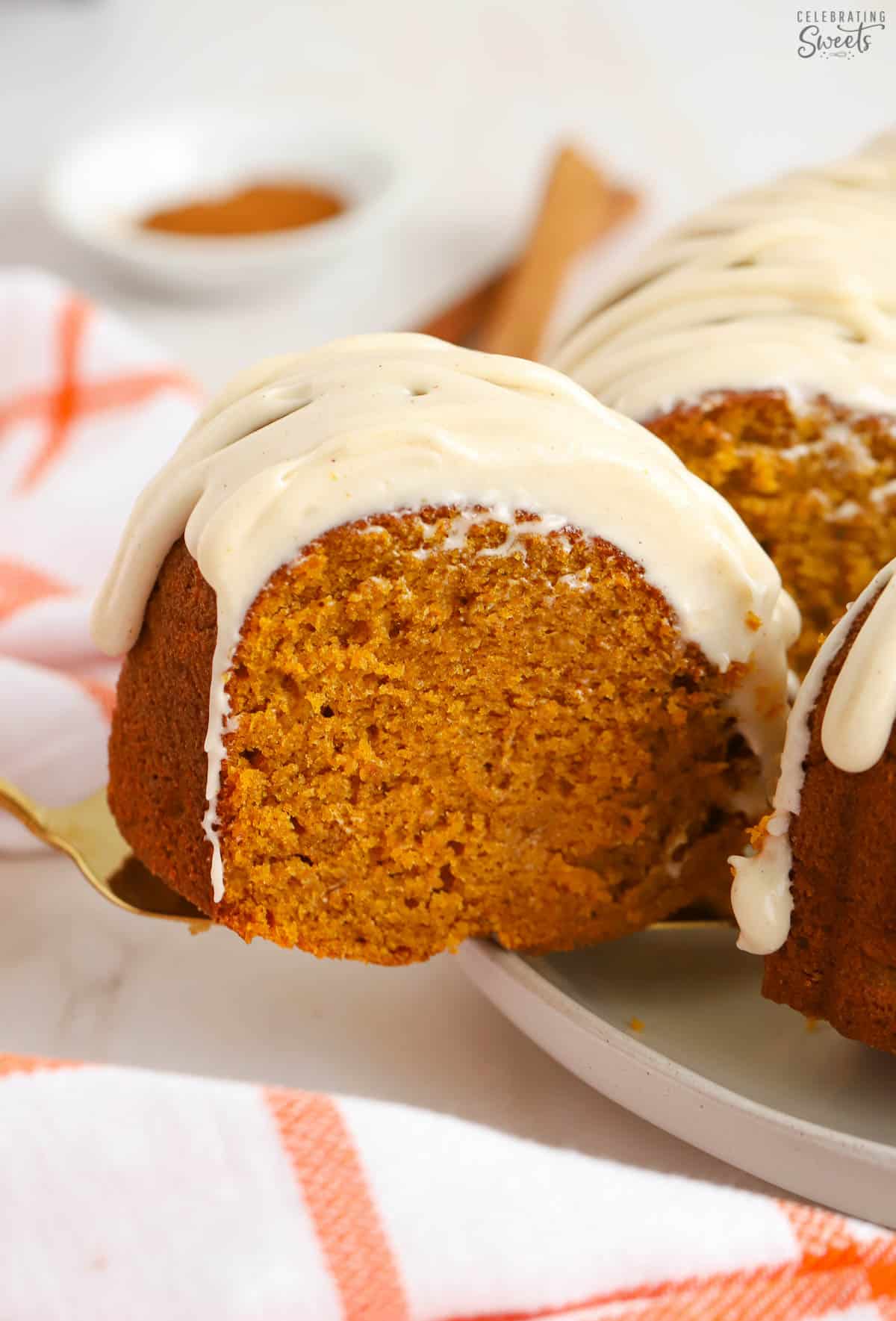 Slice of pumpkin bundt cake on a gold spatula.
