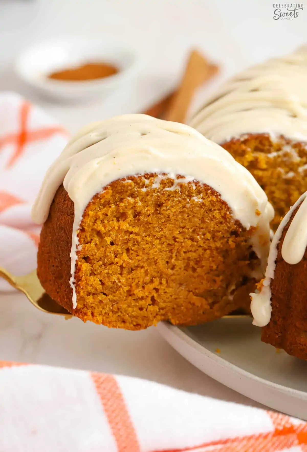 Slice of pumpkin bundt cake on a gold spatula.