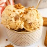 Pumpkin ice cream in a polka dotted bowl with a silver and gold spoon.