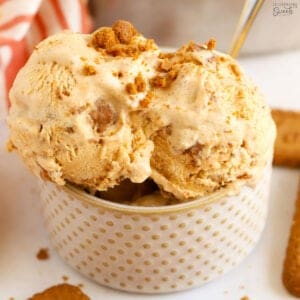Pumpkin ice cream in a polka dotted bowl with a silver and gold spoon.