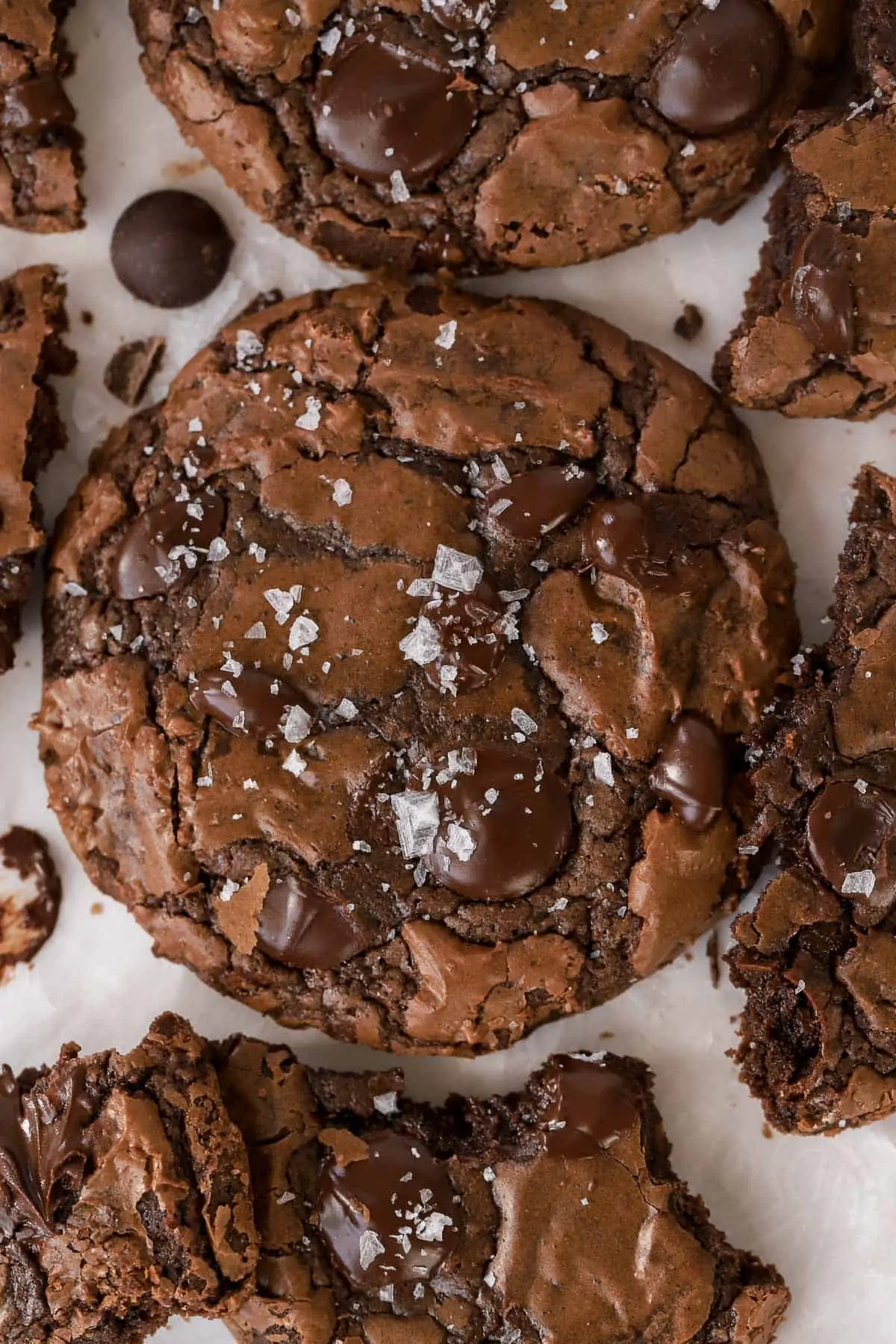 Brownie cookies on a piece of parchment paper topped with flaky sea salt.
