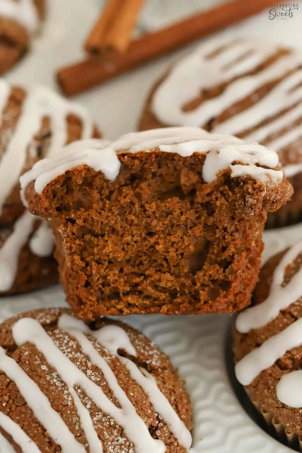 Half of a gingerbread muffin on top of a white muffin tin.