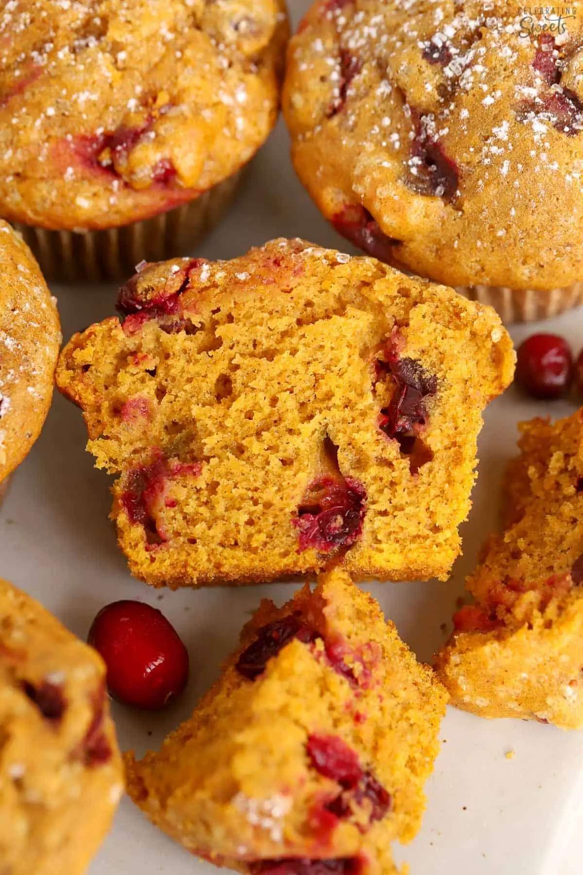Pumpkin Cranberry Muffin cut in half on a white board.